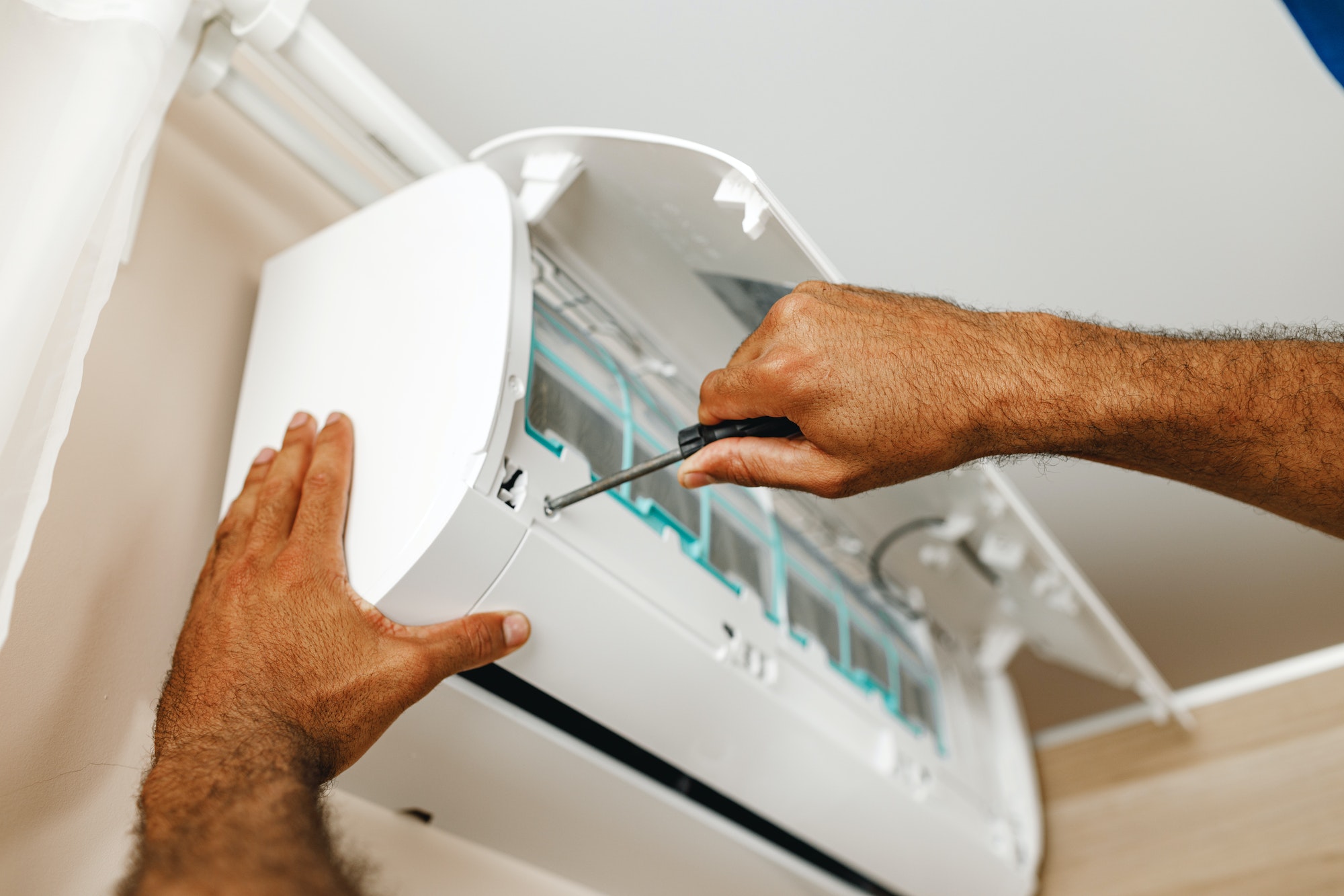 Close up of repairman fixing air conditioner in a room